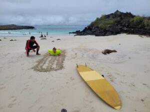 man giving woman surf lessons on Puerto Chino beach San Cristobal Galapagos