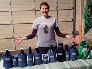 woman wearing a beer t-shirt standing with growlers of beer for a tasting event