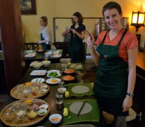 woman holding chopsticks in front of Vietnamese food at a cooking school