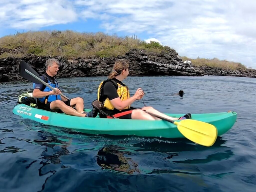 man and woman on kayak with sea lion in water San Cristobal Galapagos