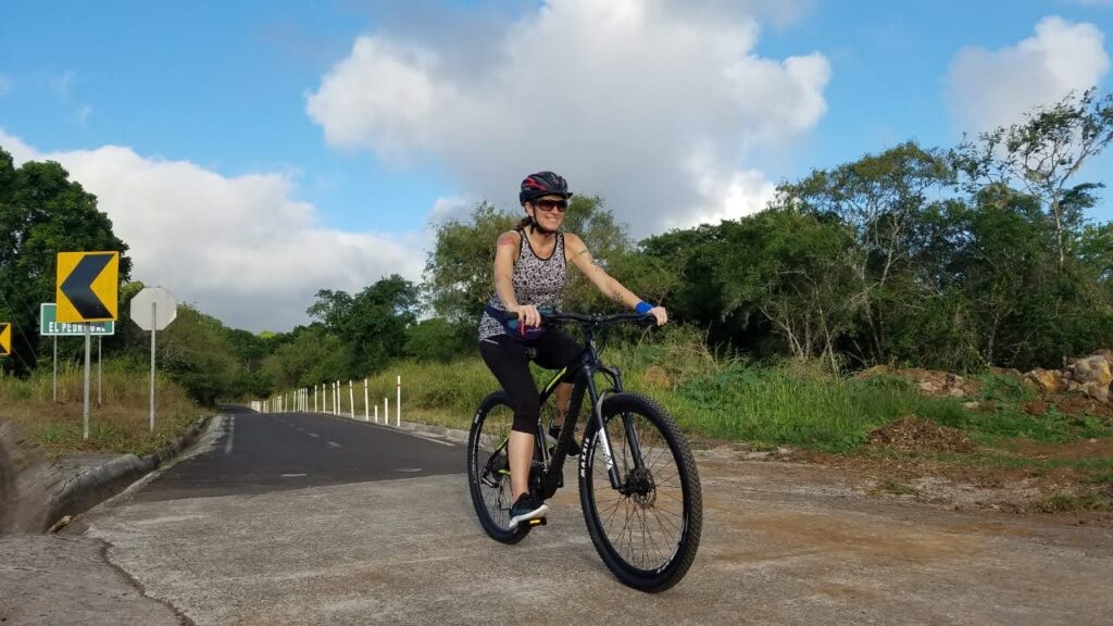 woman riding a bicycle on a paved bike trail San Cristobal Galapagos
