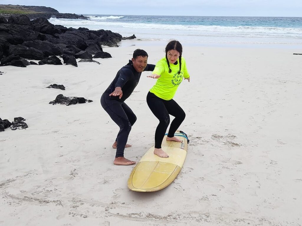 man teaching woman to surf San Cristobal Galapagos