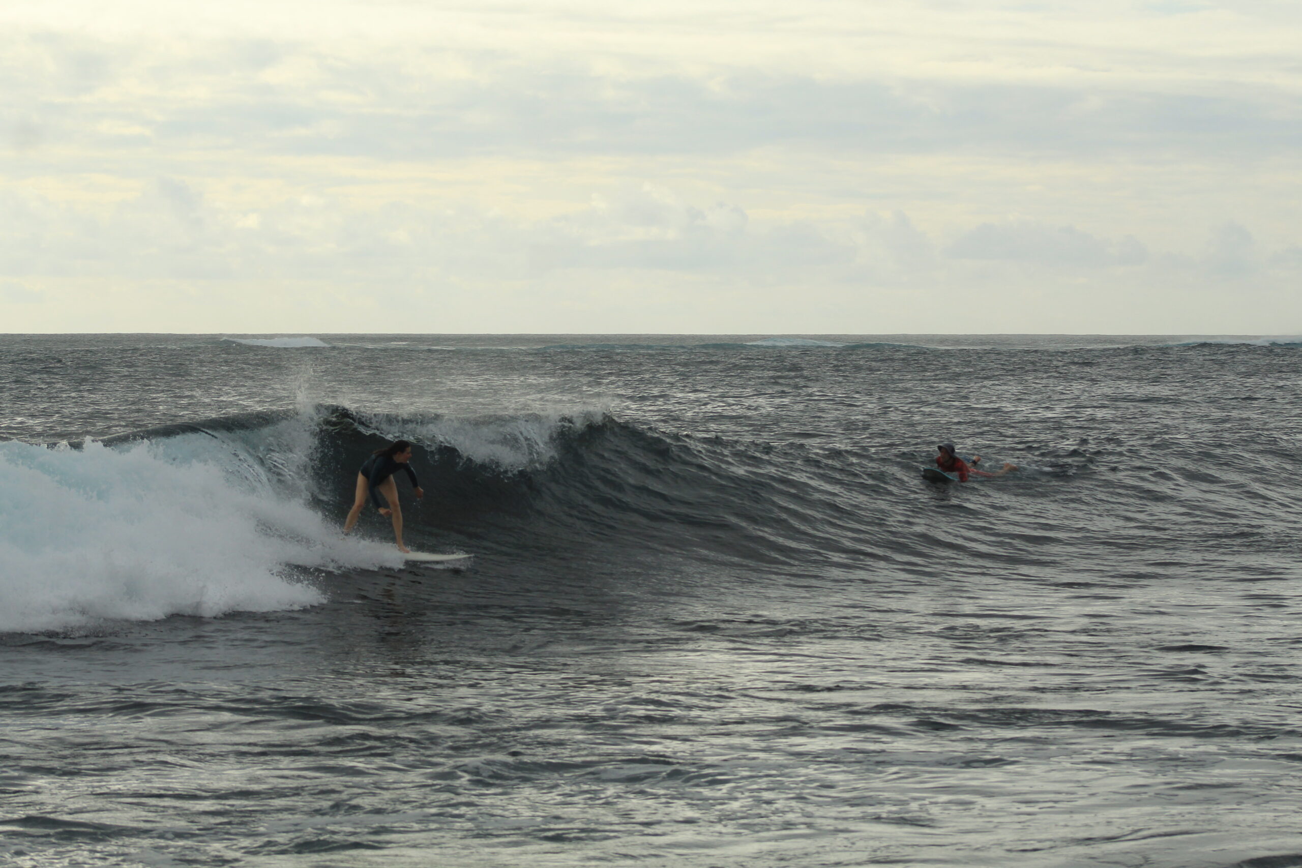 woman surfing a small wave at Tongo Reef San Cristobal Galapagos