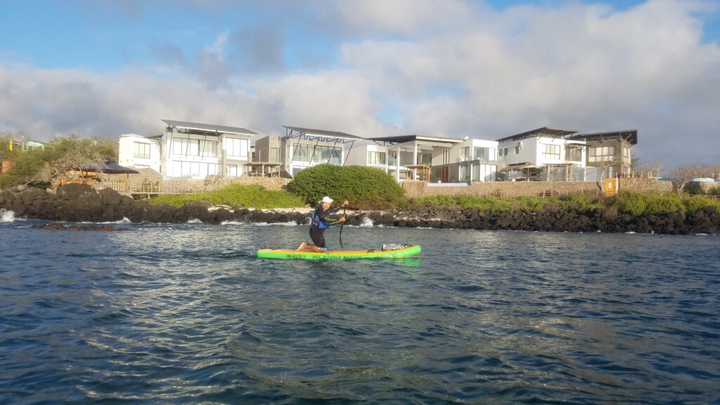 woman paddleboarding in front of hotel in San Cristobal Galapagos