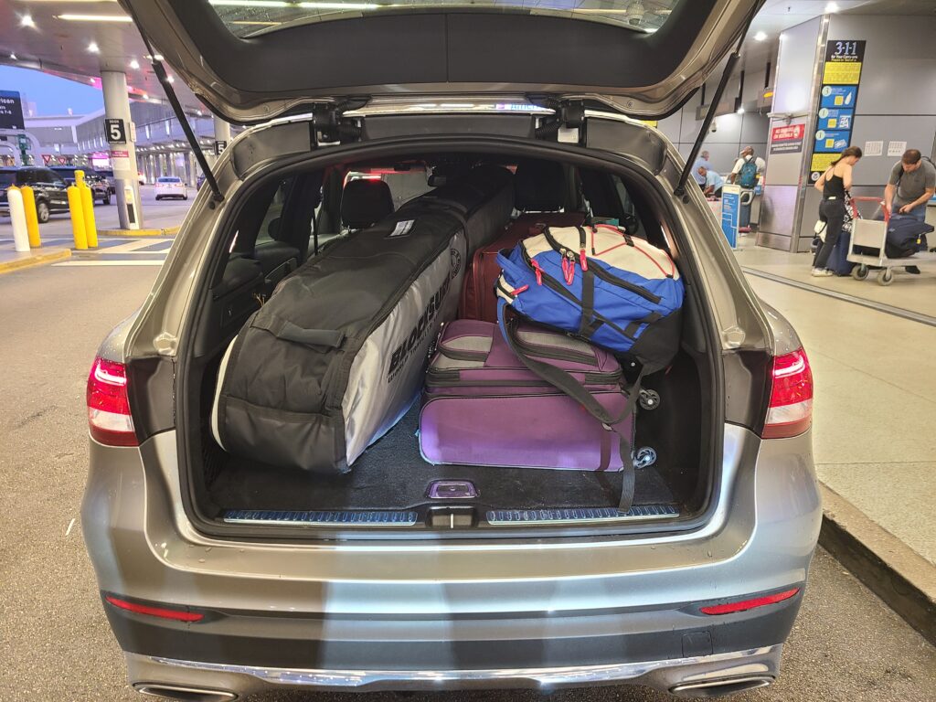 car with trunk open showing luggage for trip to Galapagos