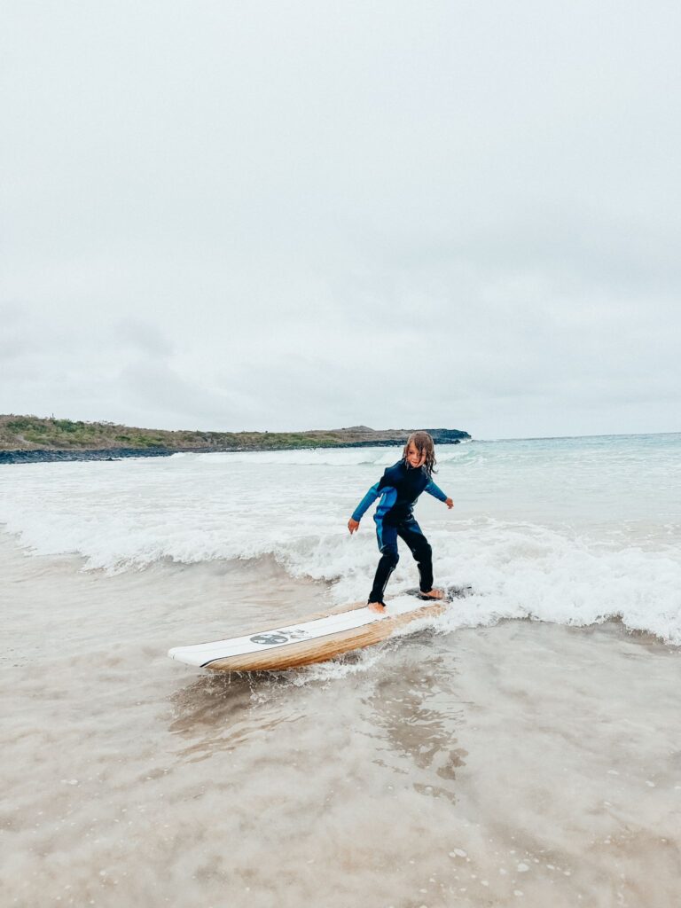 child learning to surf in Galapagos
